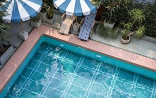 piscine extérieure avec parasols bleu et blanc