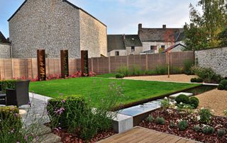 beau jardin avec pelouse, clôtures et terrasse