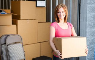 femme déposant des cartons dans son garde-meubles