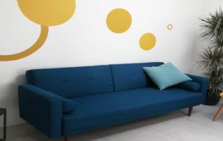 canapé bleu foncé et mur blanc avec décorations jaunes