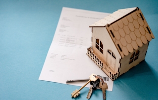 petite maison en bois posée sur une feuille