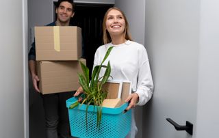 Couple portant des cartons dans leur nouveau logement