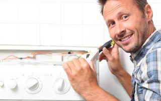 Un homme répare une machine à laver