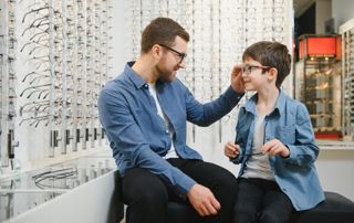 père et son fils essayant des lunettes en magasin