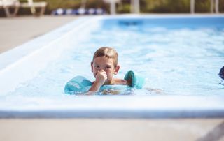 Enfant avec des bouées dans une piscine